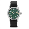 Front view of a Militado ML12 field watch with green dial, silver-tone case, and black nylon strap on white