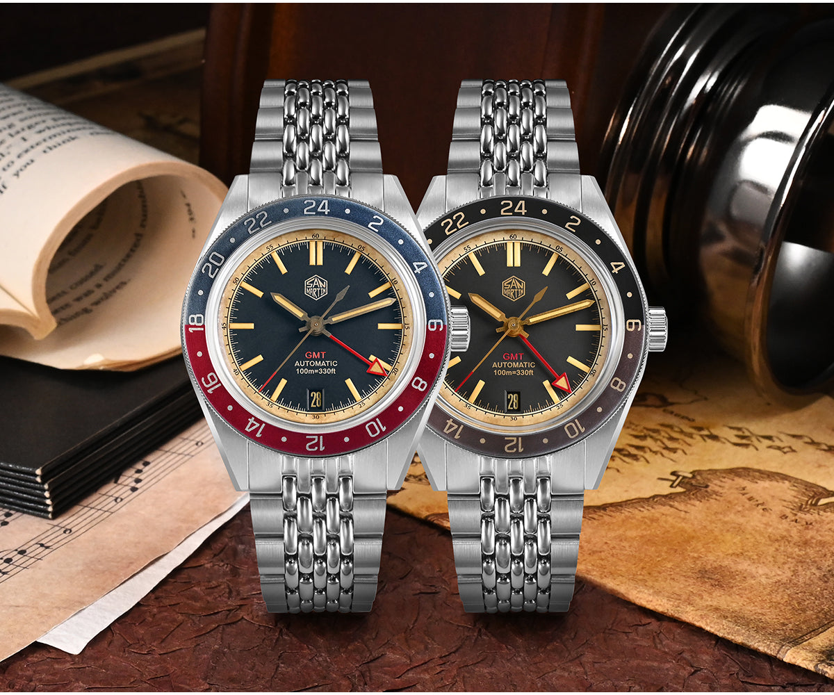 Two San Martin GMT watches with red and blue and dark 24-hour bezels displayed on stainless steel bracelets.